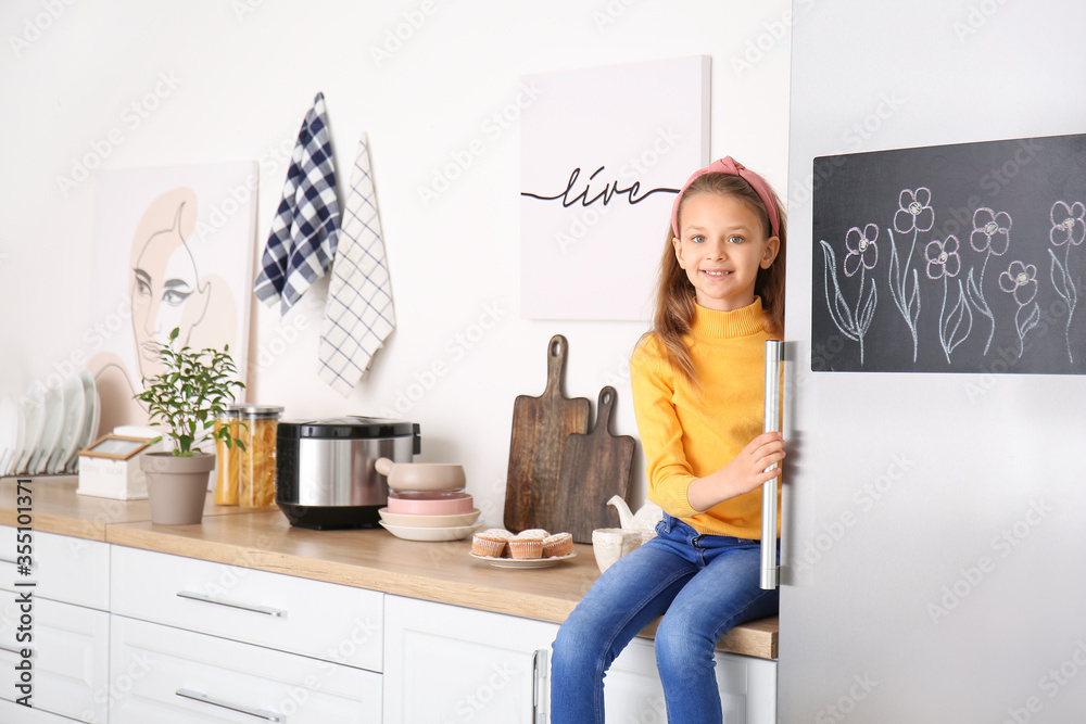 Little girl opening refrigerator in kitchen