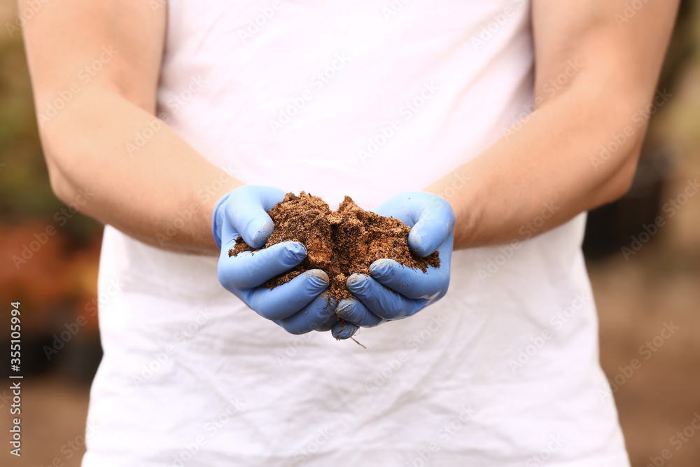 Man with heap of soil outdoors, closeup