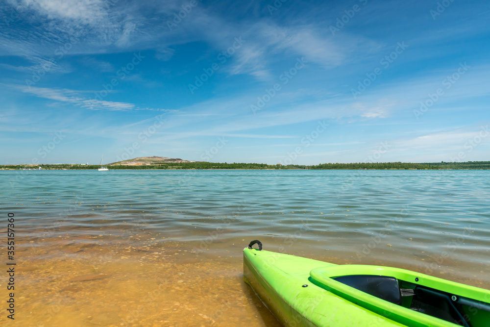 Green canoe on a beach of the Störmthaler Lake near Leipzig