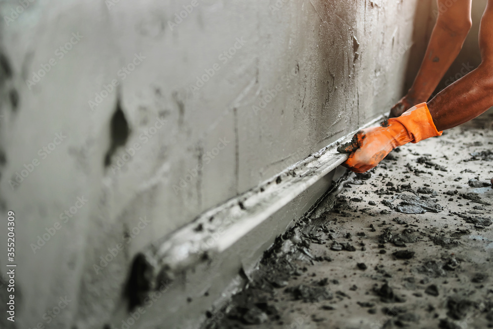 closeup hand of worker plastering cement at wall for building house