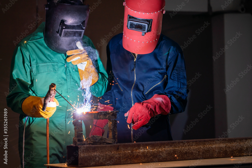 Metal welding steel works using electric arc welding machine to weld steel at factory. Metalwork man