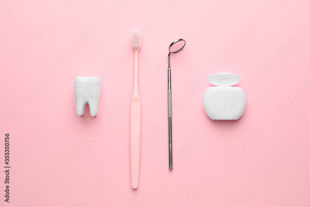 Dental mirror with toothbrush and floss on color background