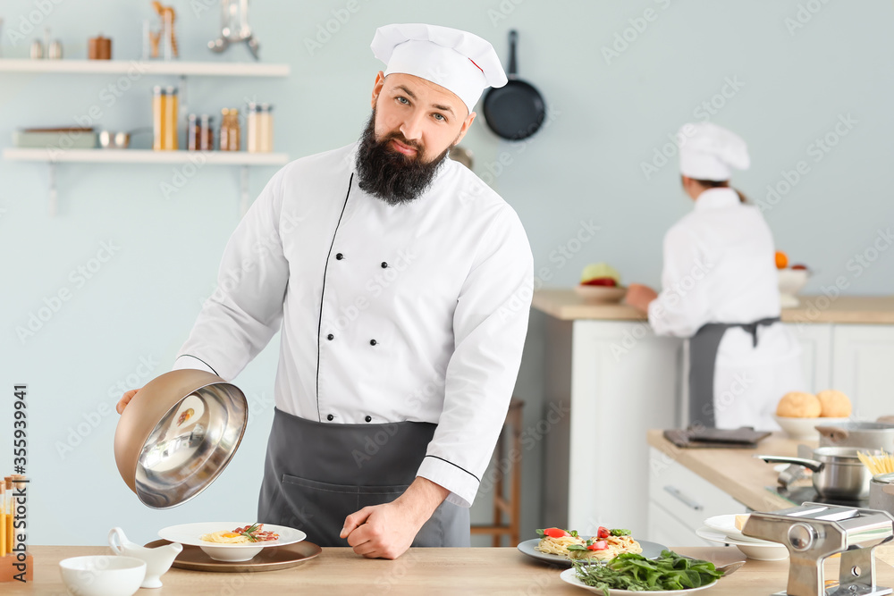 Male chef with tasty dish in kitchen