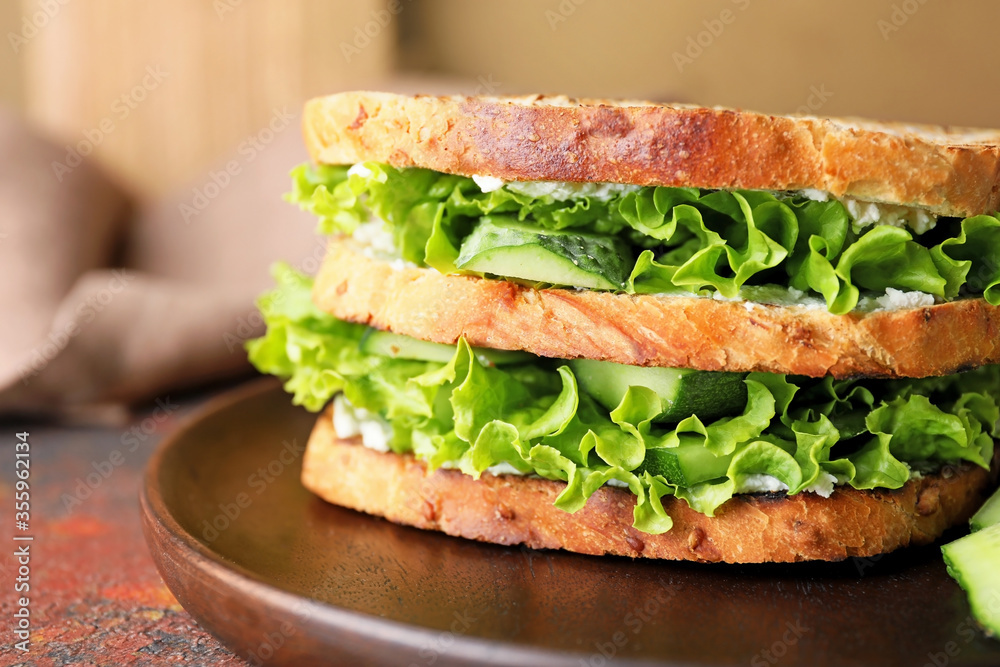 Plate with tasty cucumber sandwich on table, closeup