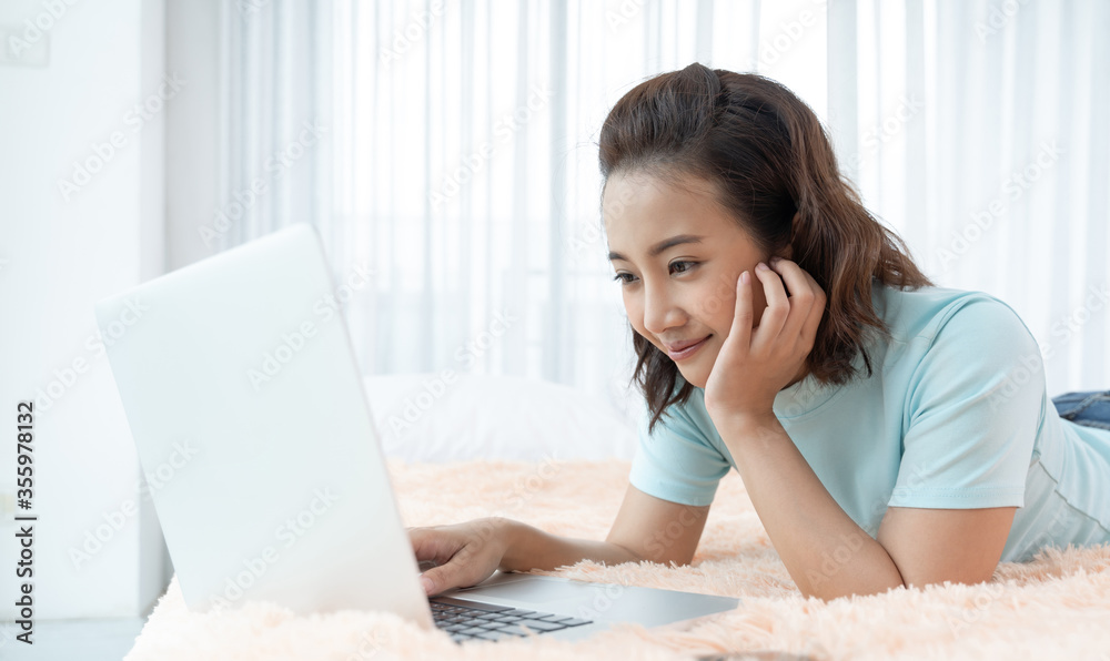 Young Asian beauty woman working on laptop in the bed at home