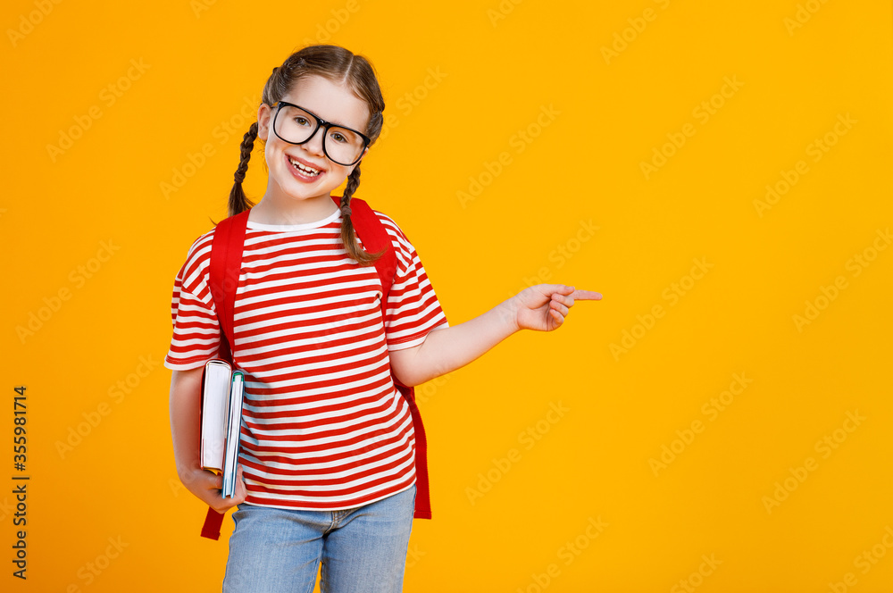 Positive schoolgirl pointing at empty space.