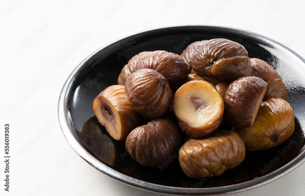 Peeled sweet chestnuts on a white background