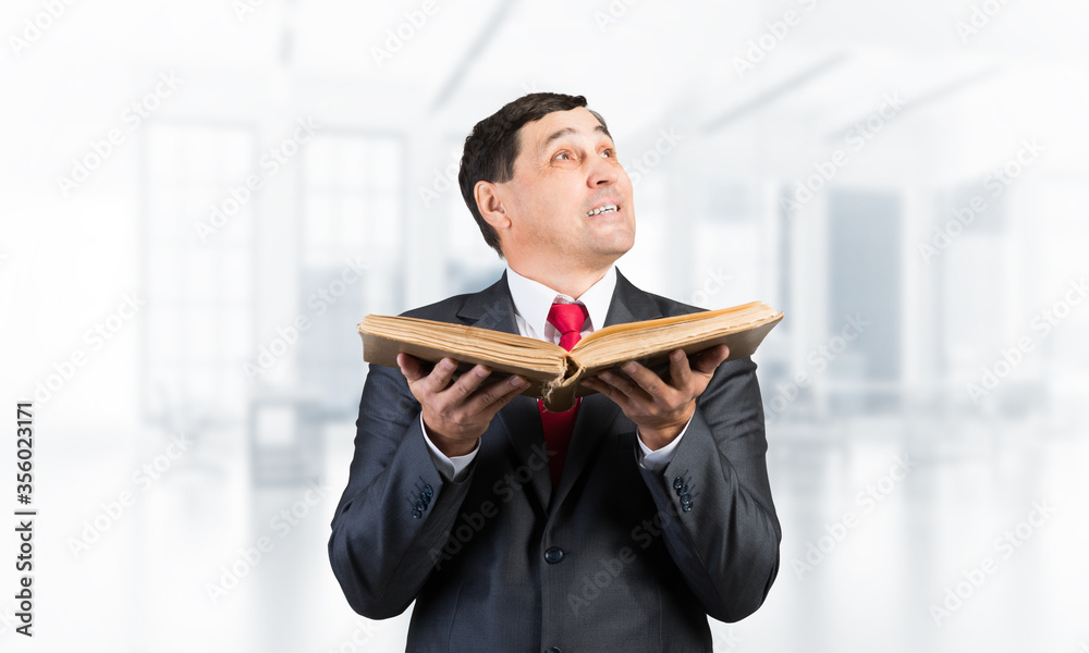 Happy senior businessman holding open book