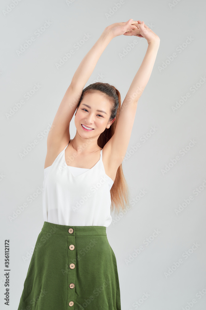 Young pretty Asian woman smiling with energetic movement and hands up over white background.