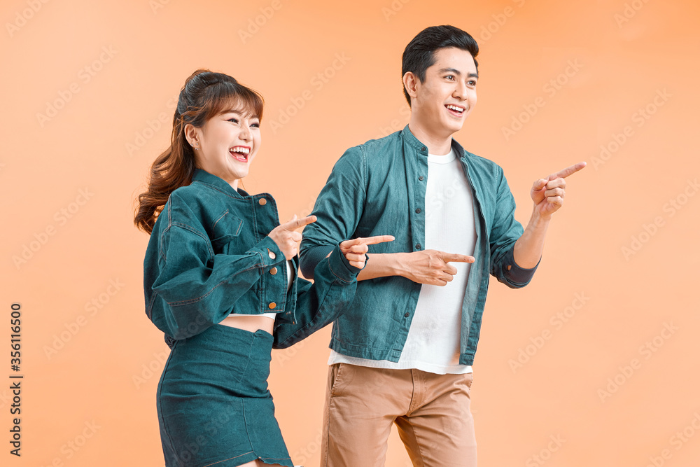 Cheerful couple pointing at one side