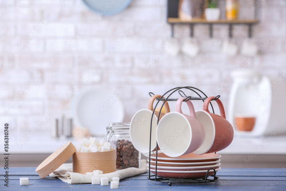 Holder with cups and saucers on kitchen table