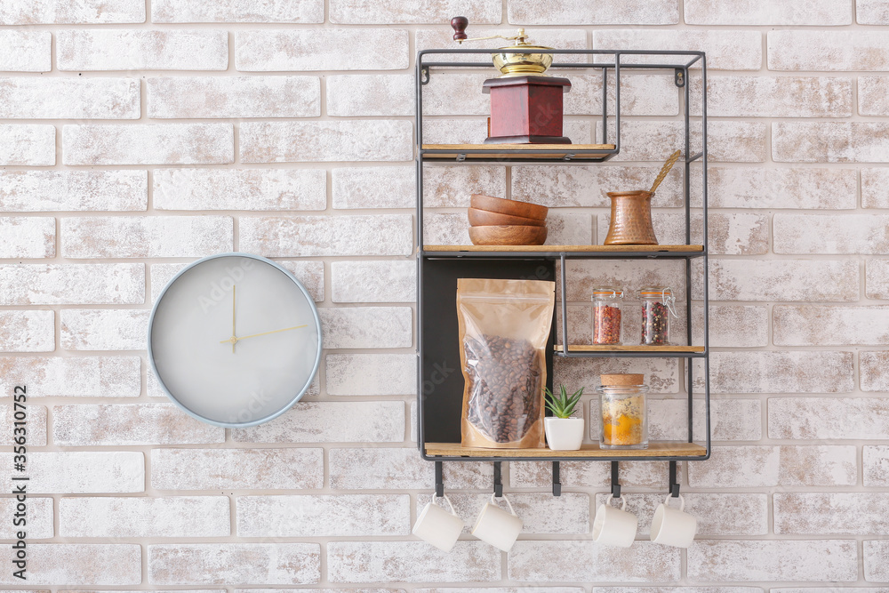 Shelf with kitchenware on brick wall