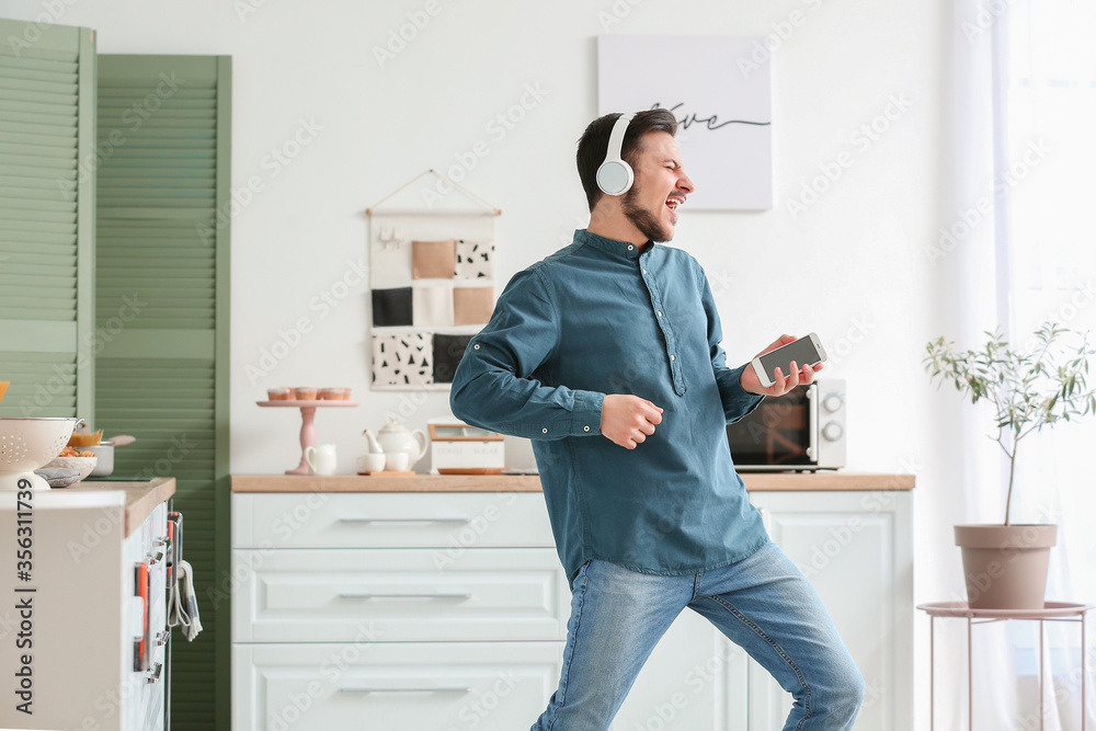 Handsome young man listening to music at home