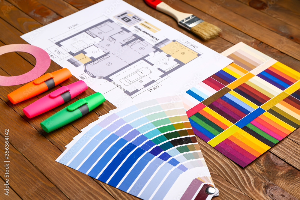 Color palettes with paint brush and building plan on wooden background