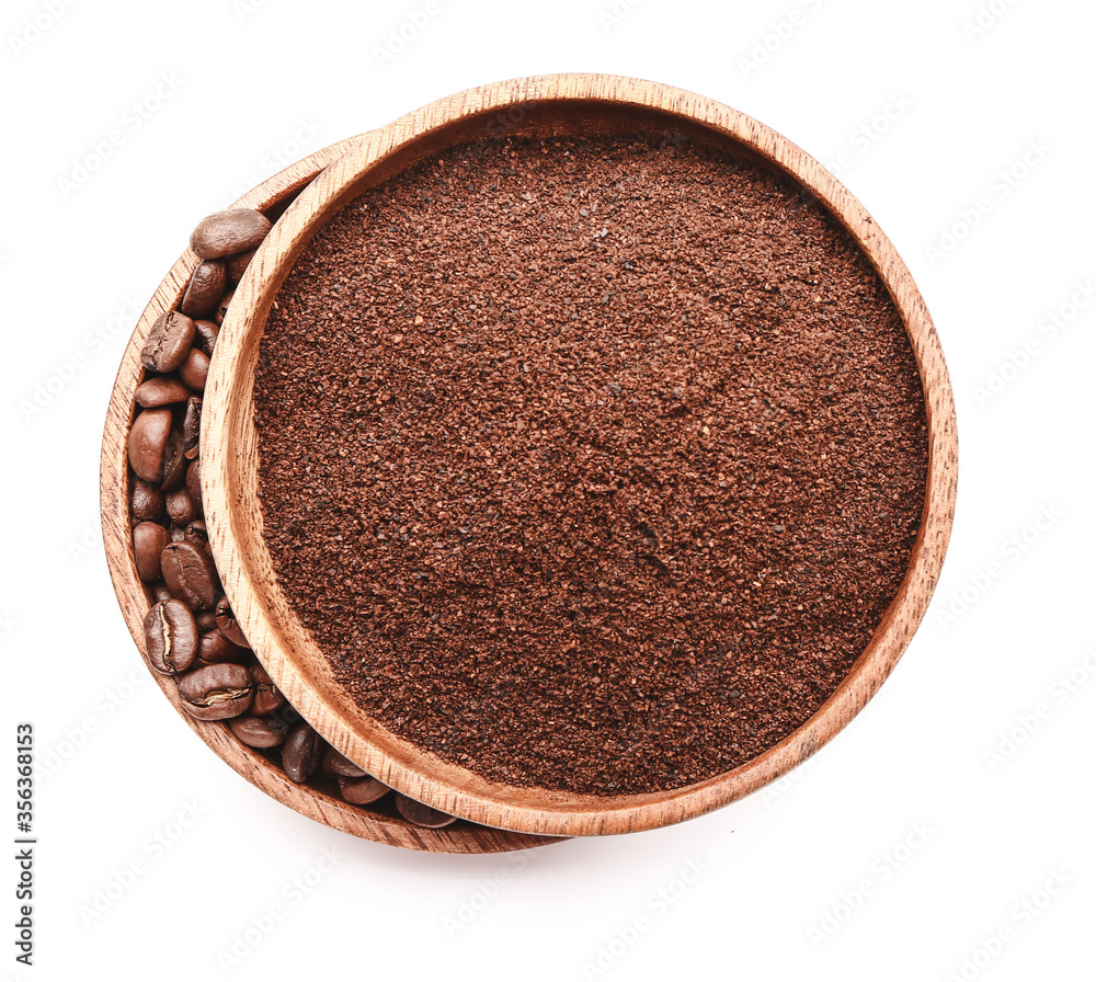 Plates with coffee powder and beans on white background