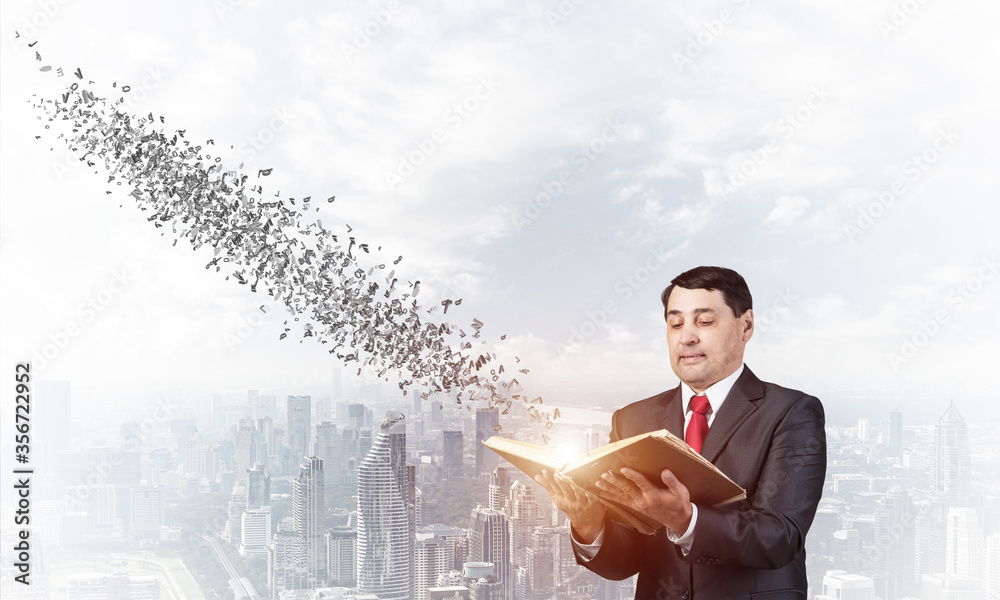 Senior businessman holding open old book