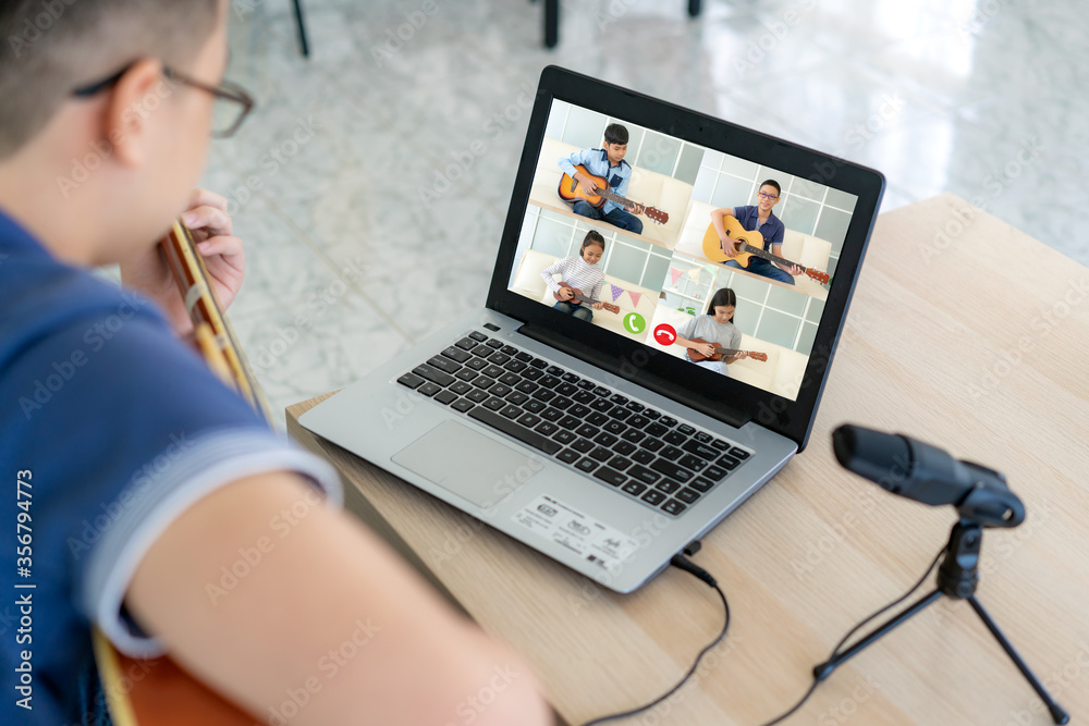 Asian boy playing acoustic guitar virtual happy hour meeting for play music online together with fri