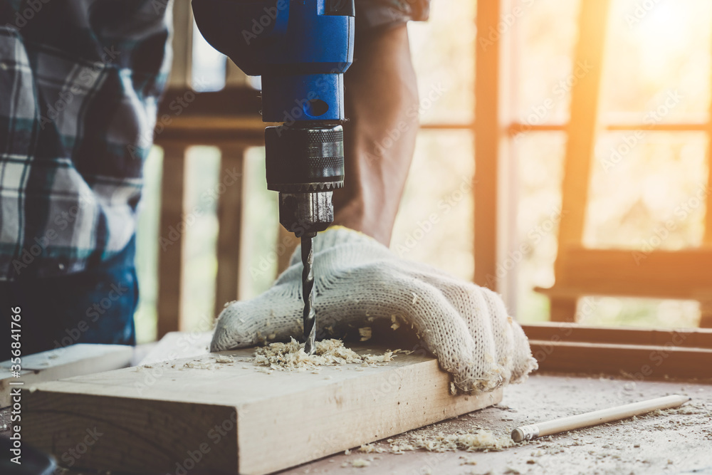 Carpenter working on wood craft at workshop to produce construction material or wooden furniture. Th