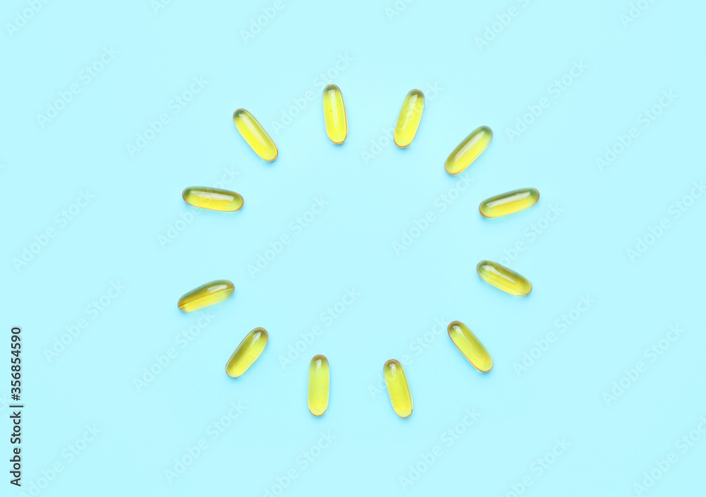 Frame made of fish oil capsules on color background