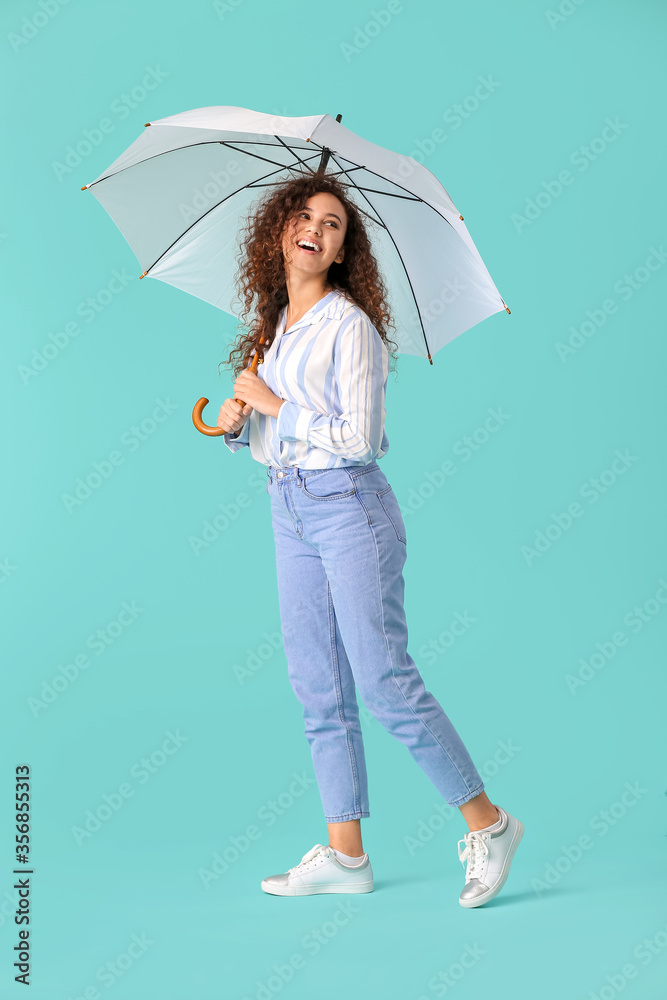 Beautiful young woman with umbrella on color background