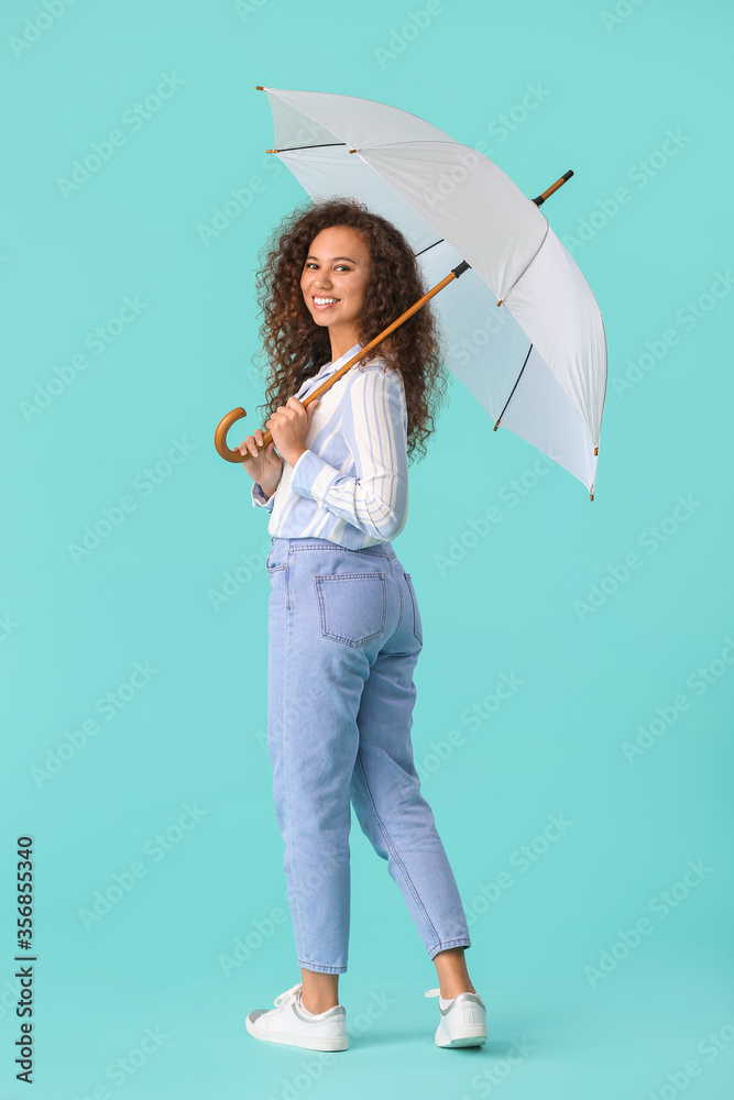 Beautiful young woman with umbrella on color background