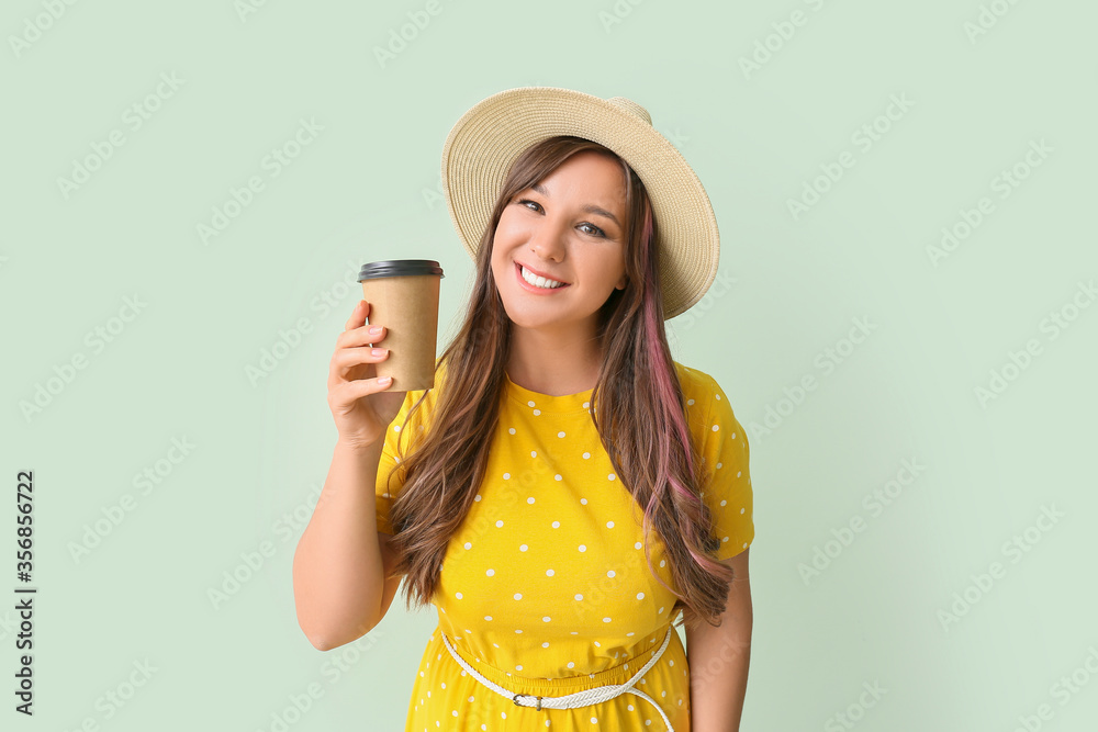 Happy woman drinking hot coffee on color background