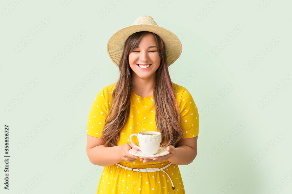 Happy woman drinking hot coffee on color background