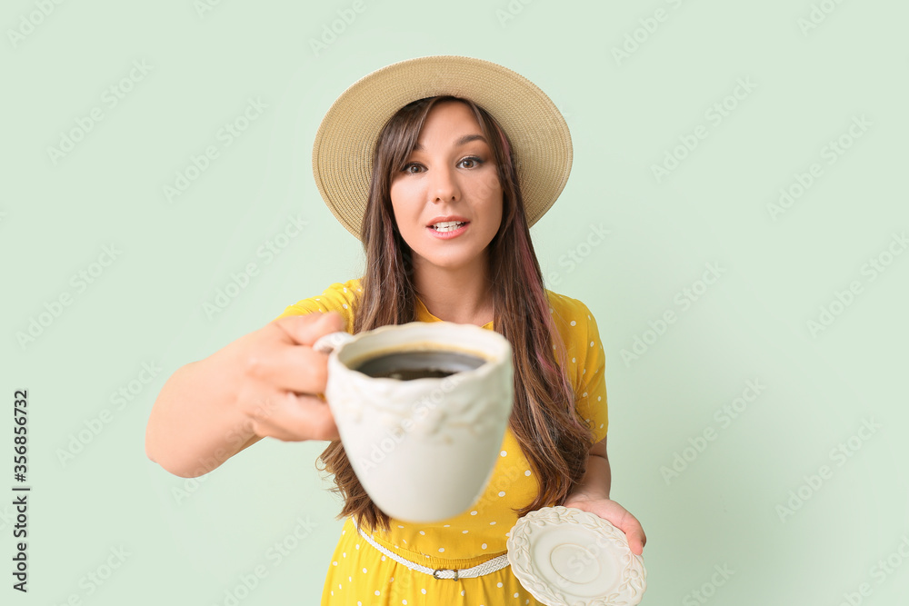 Happy woman drinking hot coffee on color background