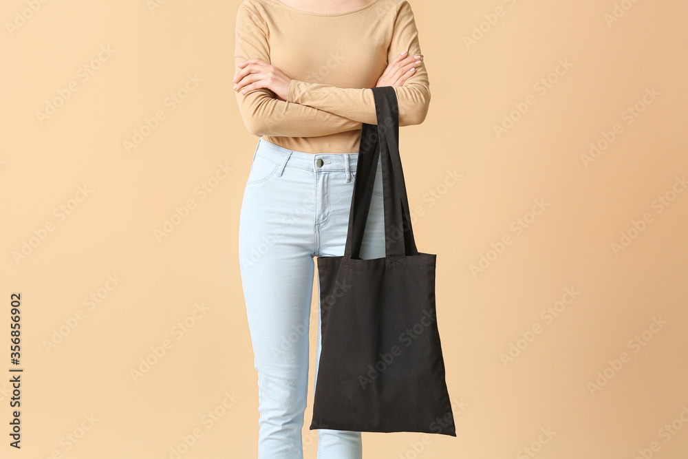 Young woman with eco bag on color background