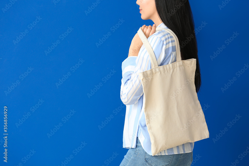 Young woman with eco bag on color background