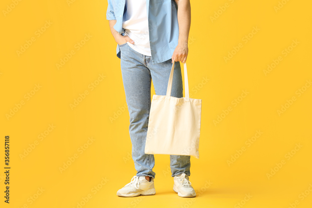 Young man with eco bag on color background