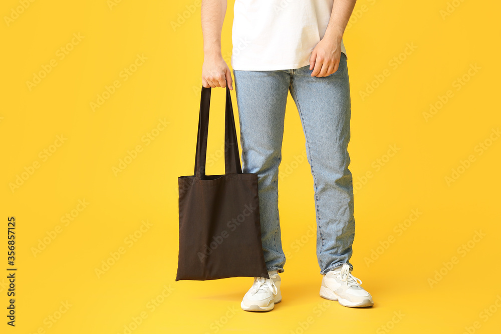 Young man with eco bag on color background