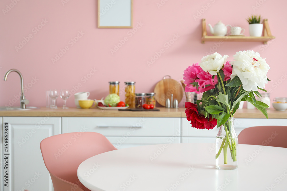 Bouquet of flowers on table in kitchen