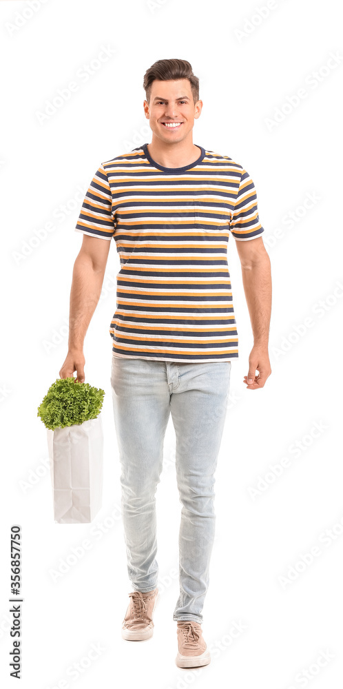 Young man holding bag with food on white background