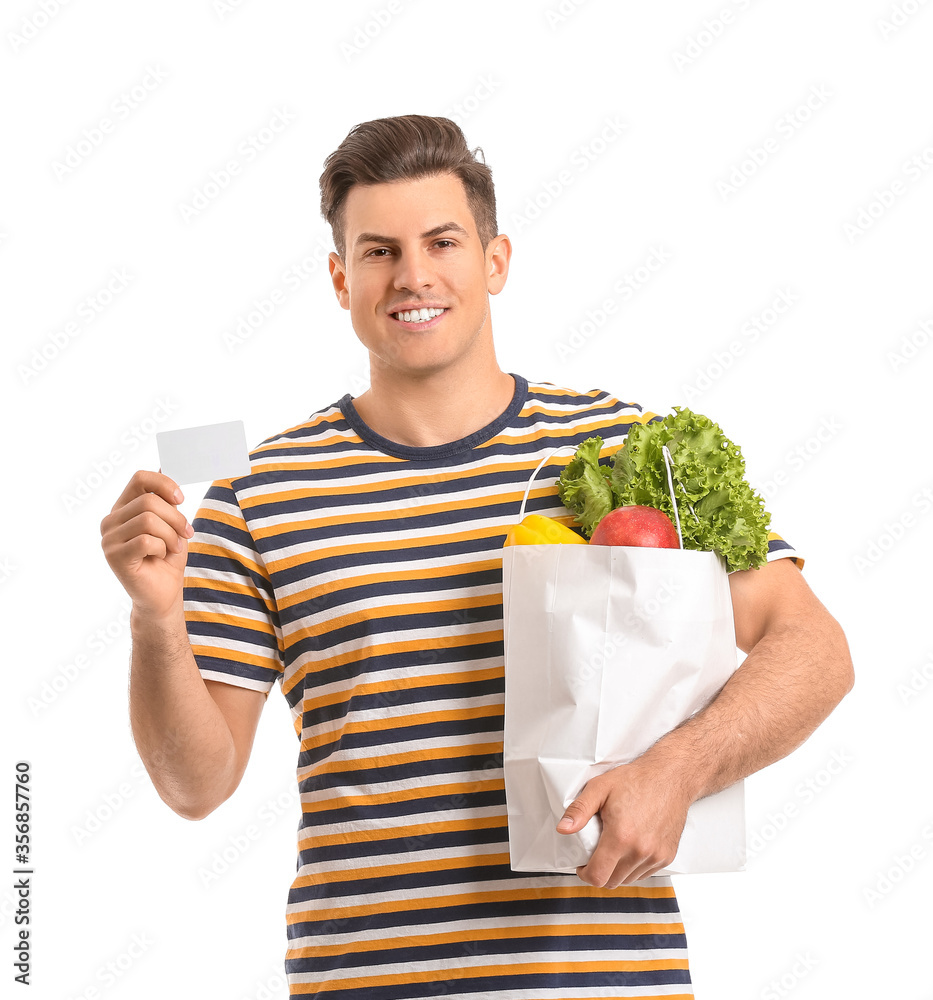 Young man with food in bag and business card on white background