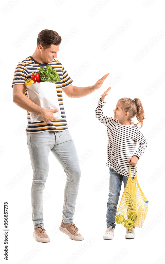 Happy father and daughter with food in bags on white background