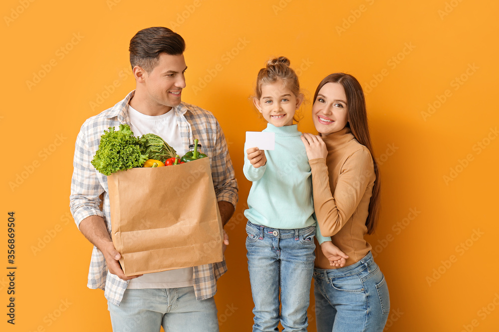 Family with food in bag and business card on color background