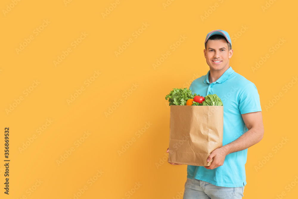 Delivery man with food in bag on color background