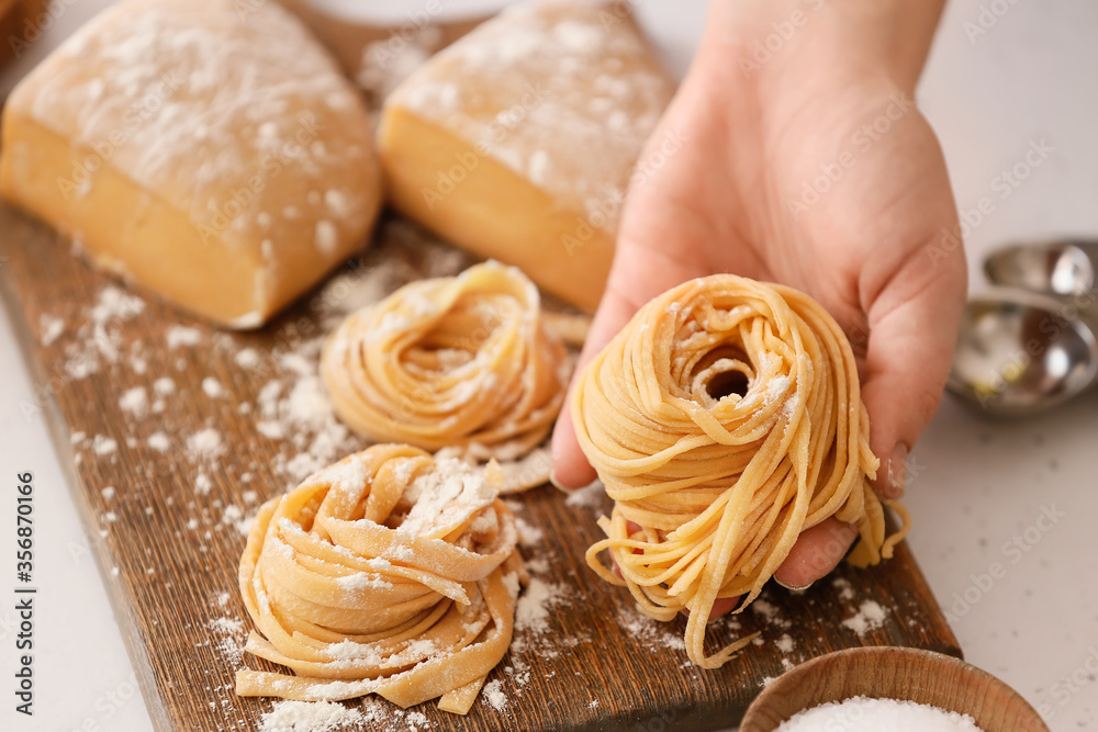 Woman preparing pasta in kitchen, closeup