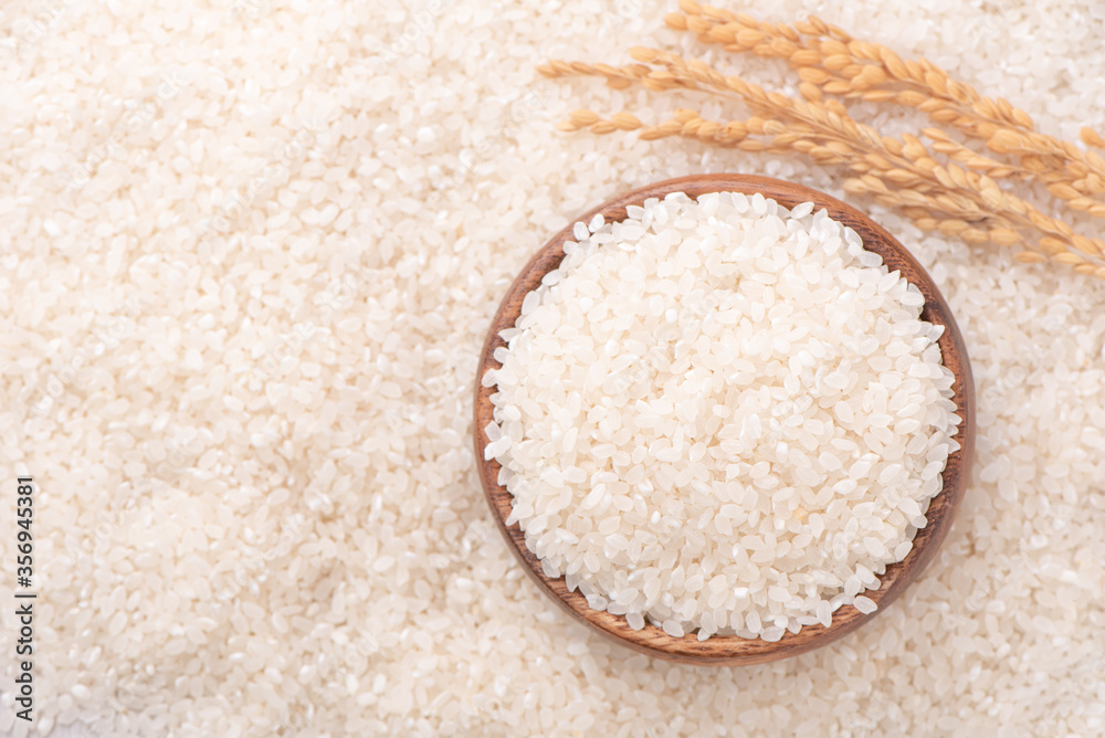 Raw rice in a bowl and full frame in the white background table, top view overhead shot, close up