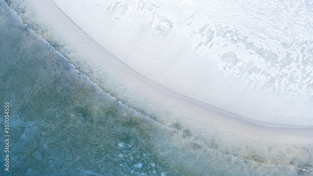 Coastline, melting ice, clear water on the sandy beach.