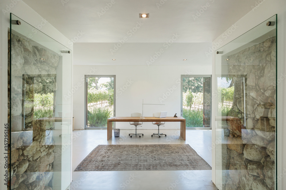 Rocks behind glass in wall of modern home office