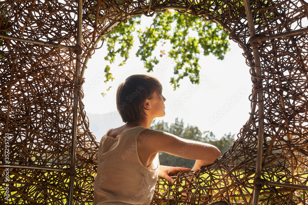 Woman looking out window of nest tree house