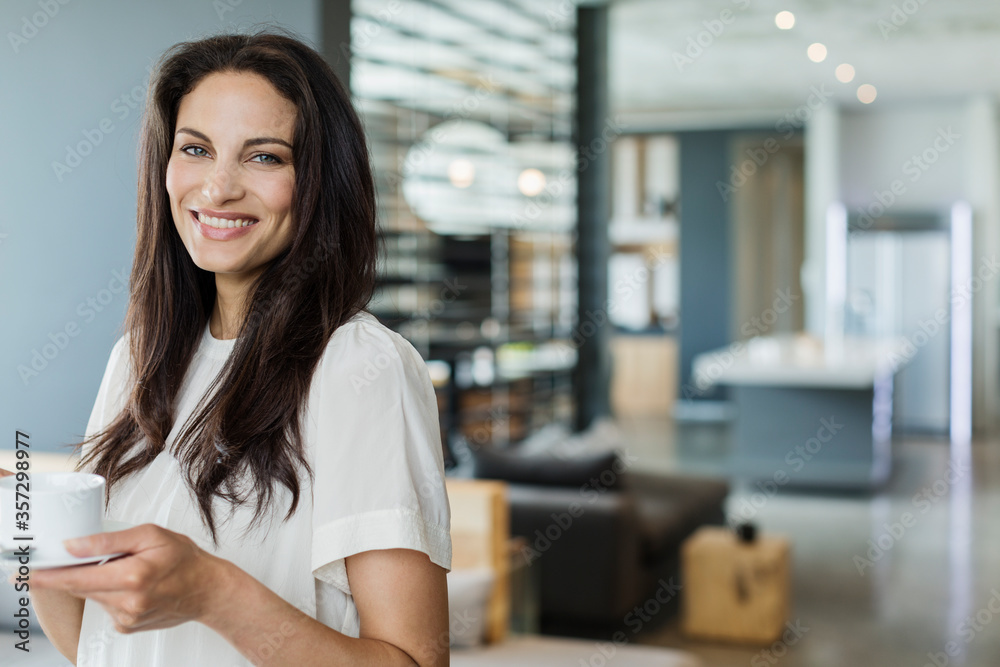 Portrait of happy woman drinking coffee at home