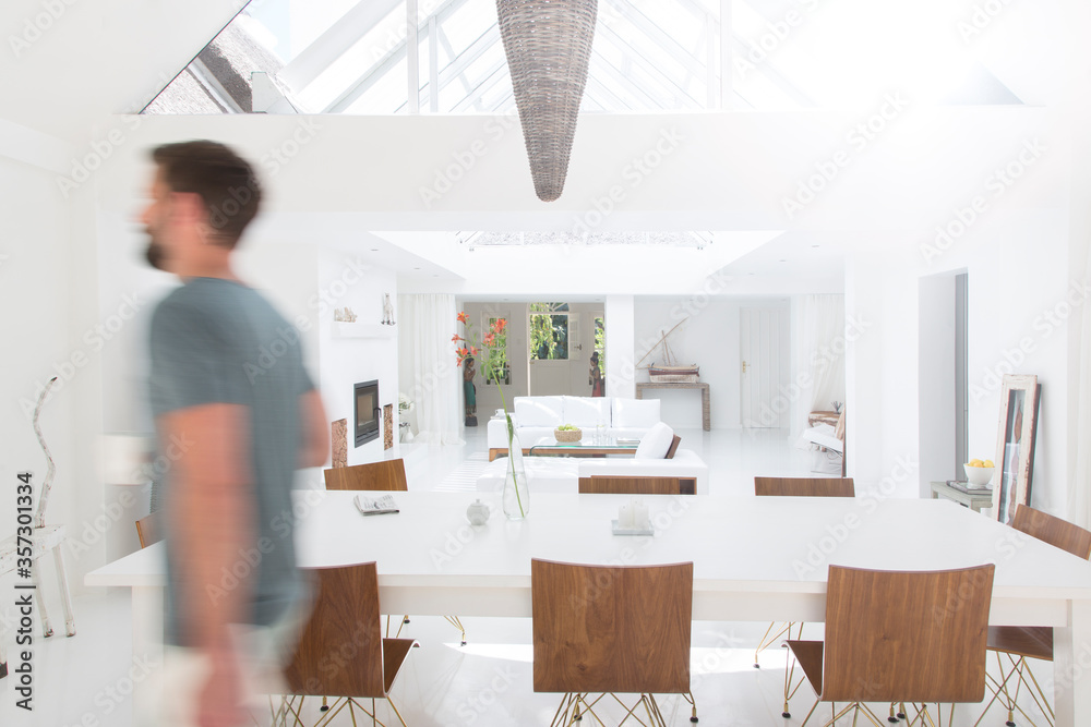 Blurred view of man walking in modern dining room