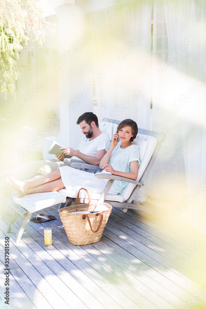 Couple relaxing in lawn chairs on wooden deck