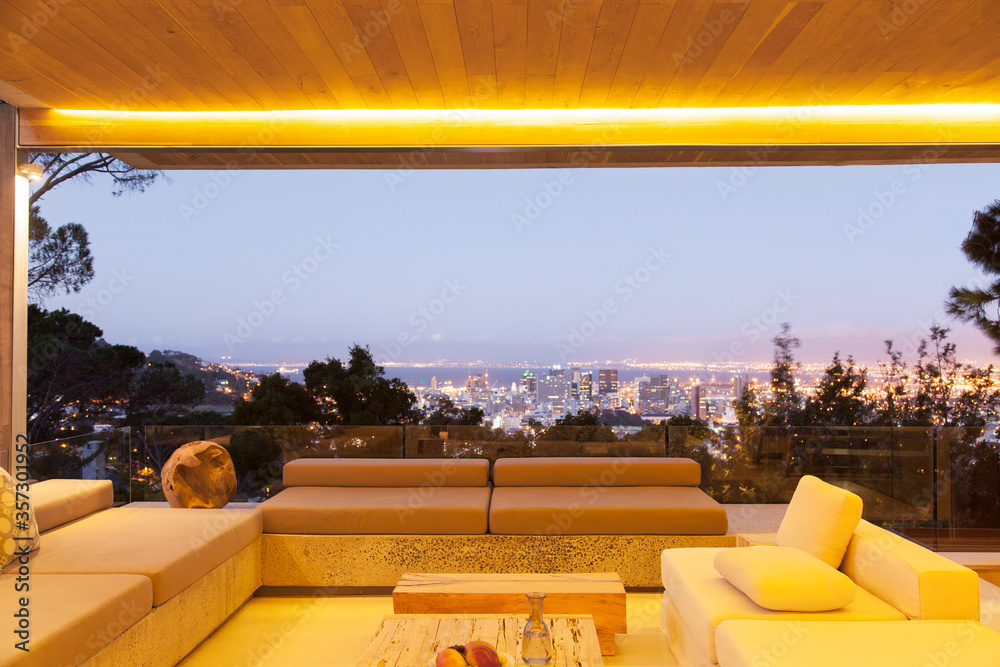 Modern living room overlooking illuminated cityscape at night