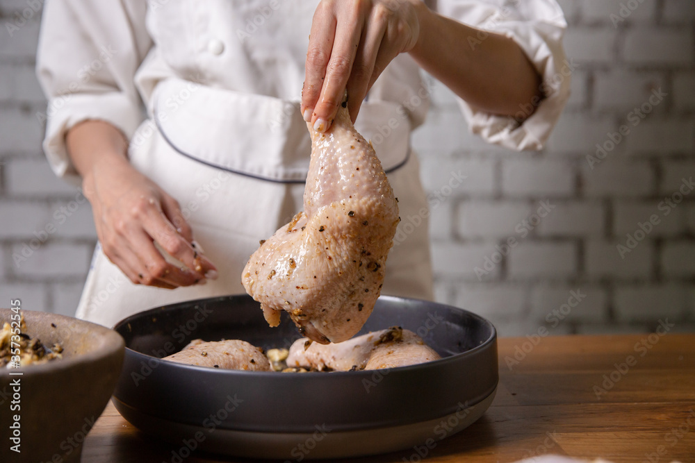 The chef cooks marinated chicken in his kitchen.