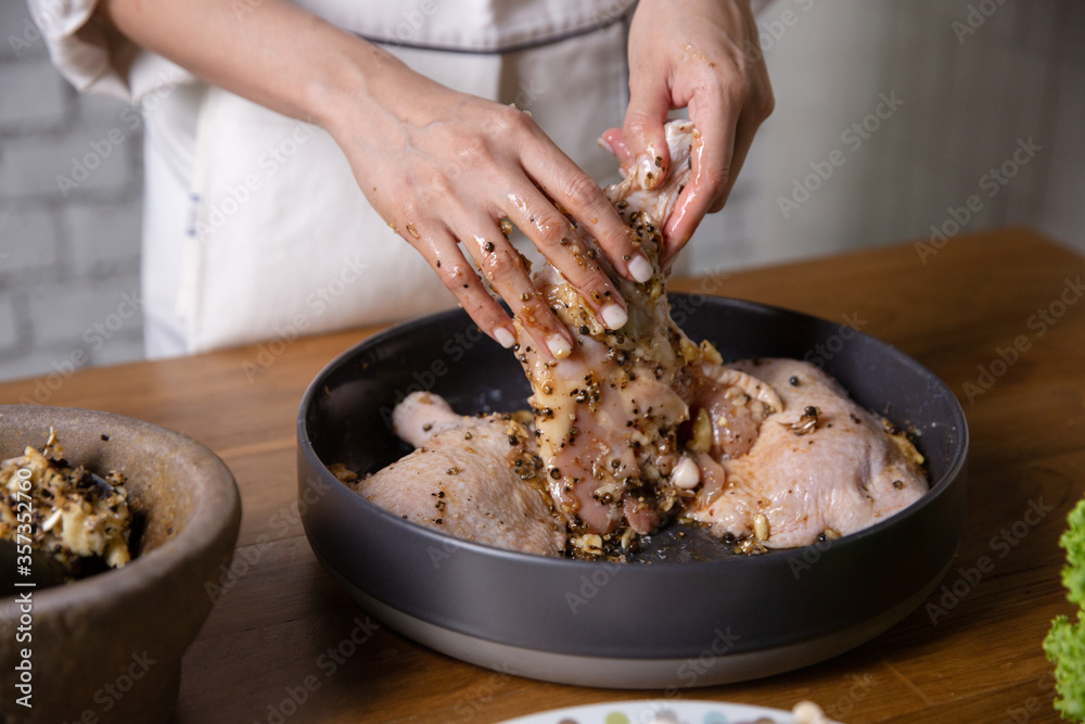 厨师在他的厨房里煮腌鸡肉。