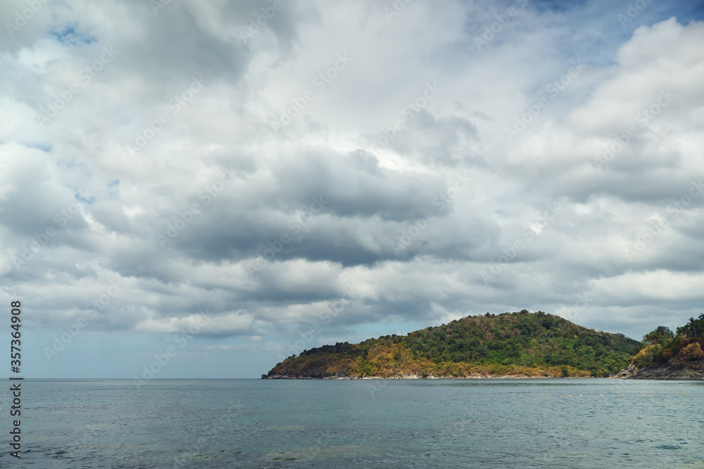 Clouds over the sea and a ledge of rocks.